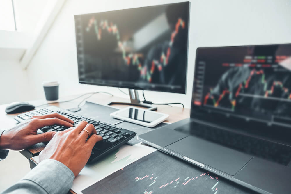 Śledzenie wykresów na monitorze oraz laptopie przed inwestowaniem w akcje
